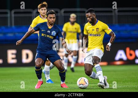 Brazilian football player Renato Ribeiro Calixto or Renatinho of Guangzhou R&F F.C., left, attempts to steal the ball from Ghanaian football player Mu Stock Photo