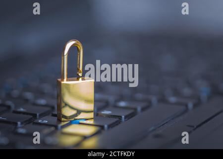 Background image of golden metal lock on keyboard, computer security Stock Photo