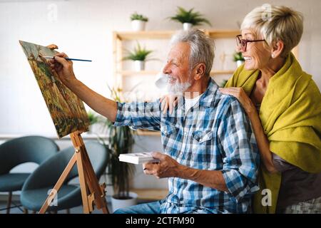 Portrait of smiling beautiful elderly couple painting Stock Photo