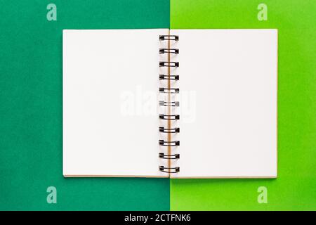 Clean spiral note book for notes and messages on green background. Minimal business flat lay Stock Photo