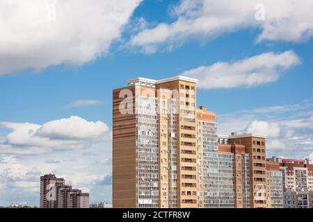 New block of modern apartments with balconies and blue sky with white fluffy clouds in the background Stock Photo