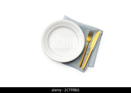 Flat lay white empty plate, blue napkin and golden cutlery isolated on white background. Fork and knife top view Stock Photo