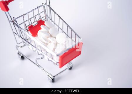 Shopping Cart Filled with Capsules Isolated On White Background. The concept of buying medicines in large quantities. Stock Photo