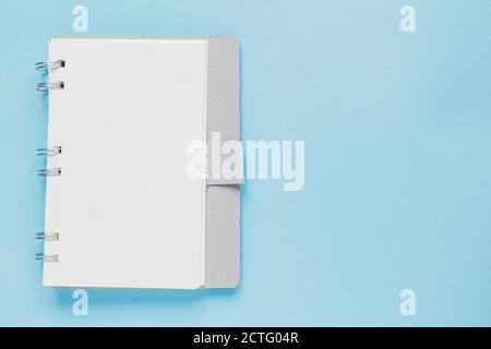 Clean spiral note book for notes and messages on blue background. Minimal business flat lay Stock Photo