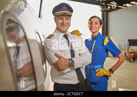 Happy workers of the airline company standing in a hangar Stock Photo