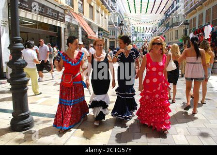 Women in flamenco dresses walking on the Calle Marques de Larios at the Malaga fair, Malaga, Malaga, Spain. Stock Photo