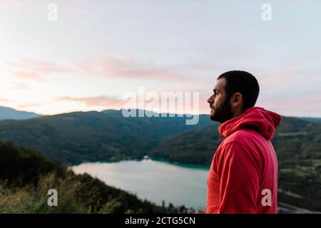 Young man enjoying the view of the lake in sunset Stock Photo