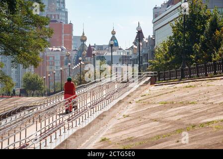 Kiev / Ukraine - September 10, 2020 - A woman climbs a long metal ramp for handicapped people, bicycles and people with strollers, near Natalka Park i Stock Photo