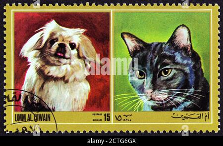 UMM AL QIWAIN EMIRATE - CIRCA 1972: A stamp printed in United Arab Emirates from the 'Dogs and Cats' issue shows dog breed and cat breed, circa 1972. Stock Photo