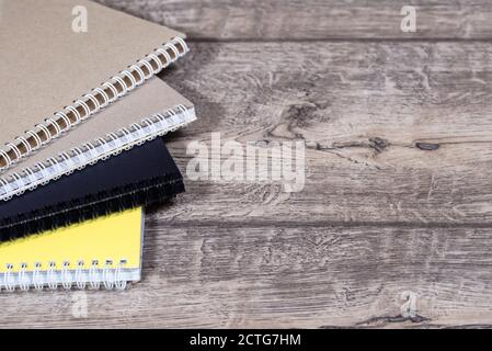 Stack of colourful notebooks with spiral edge on a wood, school or educational background Stock Photo