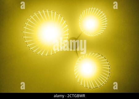 Ceiling lamp on bottom view, yellow background. Grain on photo. Stock Photo