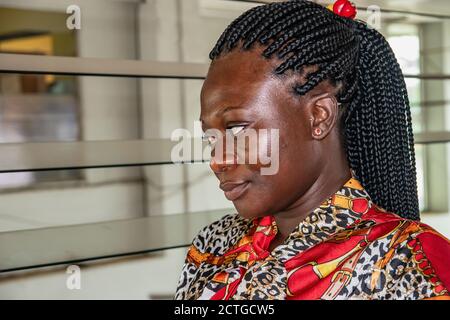 Africa woman sitting at a bus station waiting for her bus. Location Accra Ghana West Africa Stock Photo