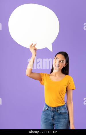 Portrait of thinking woman holding speech bubble Stock Photo