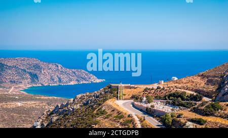 Panoramic view of Menetes village cemetery and War Memorial, with Pigadia bay in the background, Karpathos Island, Greece