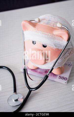 High angle view of piggy bank on table with stethoscope Stock Photo