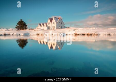 Typical view of turf-top houses in Icelandic countryside. Dramatic summer sunrise in Reykjavik, Iceland, Europe. Traveling concept background. Lonely Stock Photo