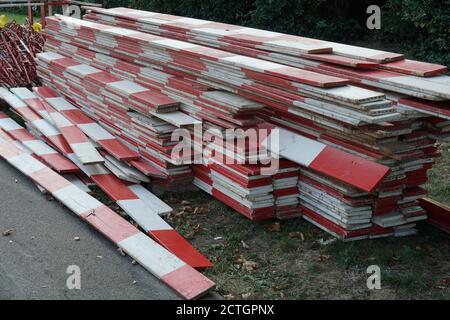 Wooden red and white barrier planks on a building or construction site of civil engineering stored on stack ready for use. Stock Photo