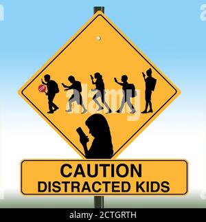 A school crossing sign includes silhouettes of children using cell phones. Stock Photo