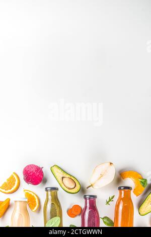 Fruit and vegetable smoothie concept. Portioned bottles with fruit and vegetable smoothies flatlay with fresh ingredients on white table background Stock Photo
