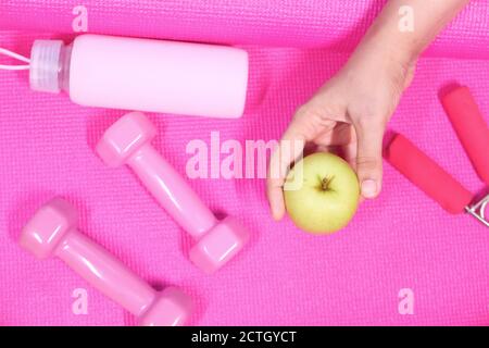 apple , pink color dumbbell, water bottle on exercise mat  Stock Photo