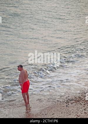 A man about to go for a swim in the sea at Brighton Stock Photo