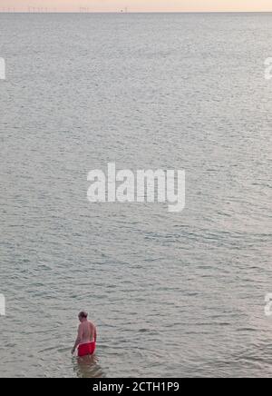 A man about to go for a swim in the sea at Brighton Stock Photo