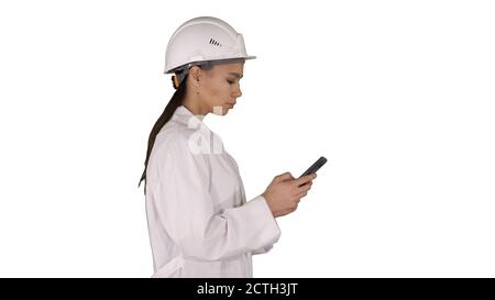 Engineer using mobile phone texting while walking on white backg Stock Photo