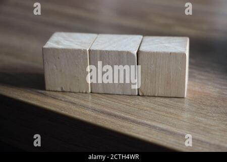 Three Wooden Blocks Front View, On Wooden Table border. Education basics concept Stock Photo