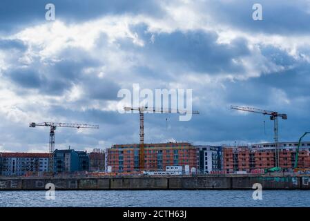 A construction site with three cranes, construction site in Berlin, Germany, three cranes on a construction site, dark clouds Stock Photo