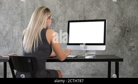 Businesswoman using desktop computer in creative office. White D Stock Photo