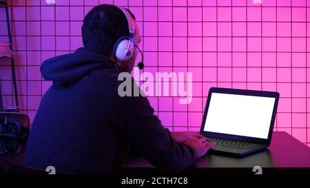 Professional Gamer Playing Video Game on His Laptop. White Displ Stock Photo