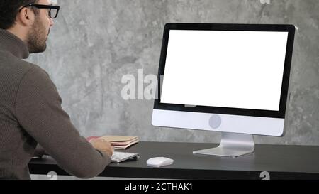 Elegant businessman analyzing data in office on his computer. Ba Stock Photo