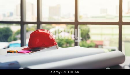 safety helmet and the blueprint at construction site Stock Photo