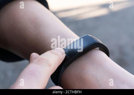 communication technologies concept- a woman uses her finger to adjust the smartwatch close-up Stock Photo