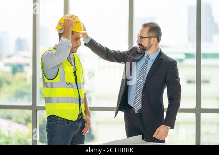 businessman wearing hard safety helmet hat for safety project of workman as engineer or worker Stock Photo