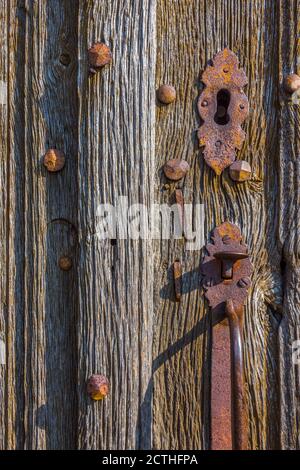 Old metal handle on weathered oak church doors - Oradour-Saint-Genest, Haute-Vienne (87), France. Stock Photo