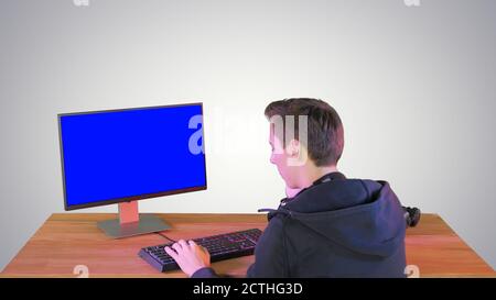 Gamer or hacker answering a phone call on gradient background. Stock Photo