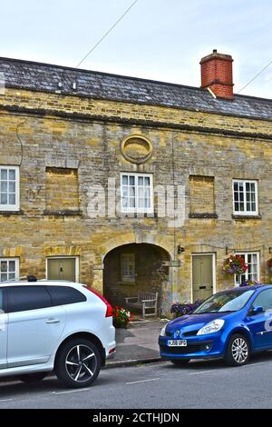 A detail of the archway and wall plaque of Tontine Buildings, a terrace of homes on Cecily Hill,Cirencester.Windows bricked up to avoid 'window tax'. Stock Photo