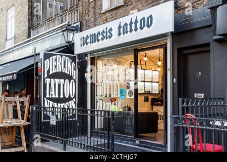 Nemesis tattoo and piercing parlour on Inverness Street, of Camden High Street, London, UK Stock Photo