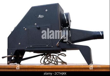 Vintage black metal Leitz episcope made around 1955 on a wooden table at an antique market in Tongeren, Belgium. Isolated on white Stock Photo
