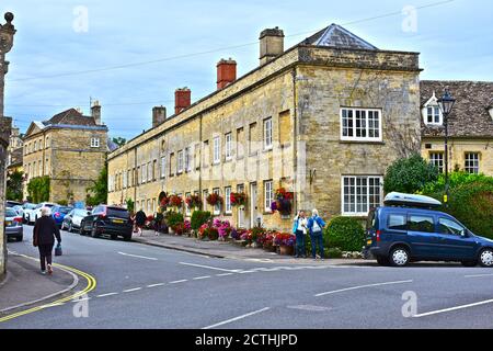 Pretty flowers outside old stone houses on Cecily Hill Cirencester. Some windows blocked up to avoid old 'window tax' from 18th & 19th century. Stock Photo