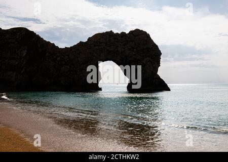 Late afternoon silhouetted view of picturesque Durdle Door rock formation on the Jurassic Coast World Heritage site in Dorset, south-west England Stock Photo