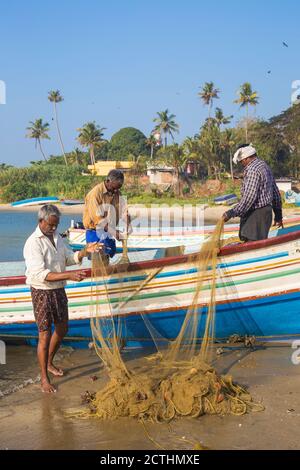 India, Kerala, Kollam, Fishing boats on beach with Tangasseri Lighthouse in background Stock Photo