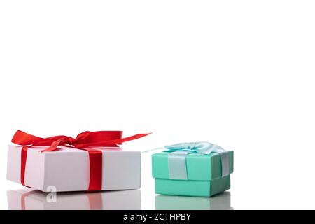 Two cardboard gift boxes with ribbons and bows on glass table surface Stock Photo