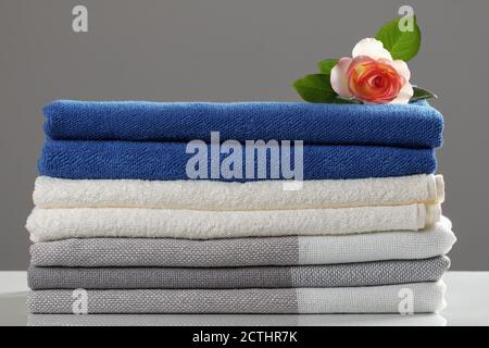 Stack of folded plaid blankets and towels on a gray background.Textile set close-up. Stock Photo