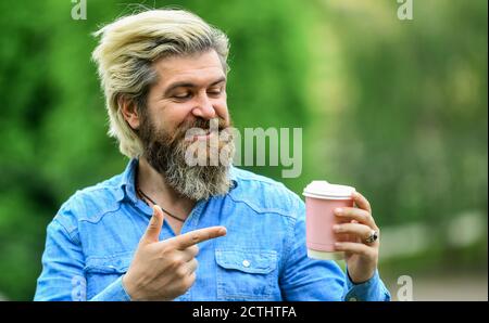 Amazing coffee. enjoys relaxing on weekend. morning drinks concept. student on coffee break. bearded man drinking coffee while walking outdoors. bearded hipster guy wearing casual clothes. Stock Photo