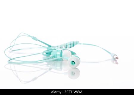 Light green color earphone selective focus isolated on white backdrop copy space Stock Photo