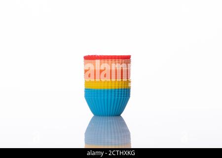 stacked multicolored small silicone cupcake molds isolated on white background Stock Photo