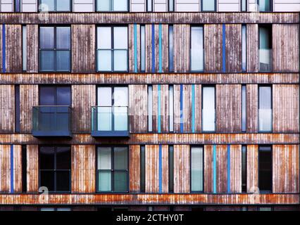 Modern architectural vertical wood cladding of flats and apartments with balconies and windows Stock Photo