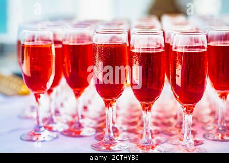 soft focus. Glasses with Rose wine for guests at the buffet table before the wedding ceremony. A lot of glasses with red champagne on the banquet tabl Stock Photo